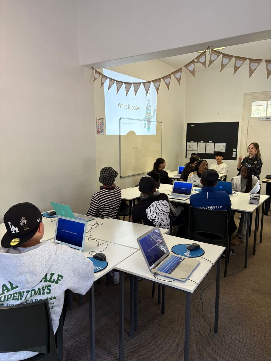 Learners working on laptops in class